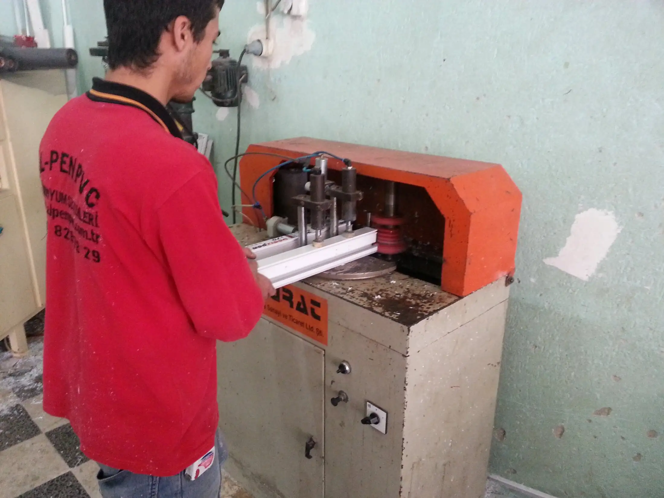 AL-PEN atölyesinde PVC profil kaynak makinesinde çalışan usta