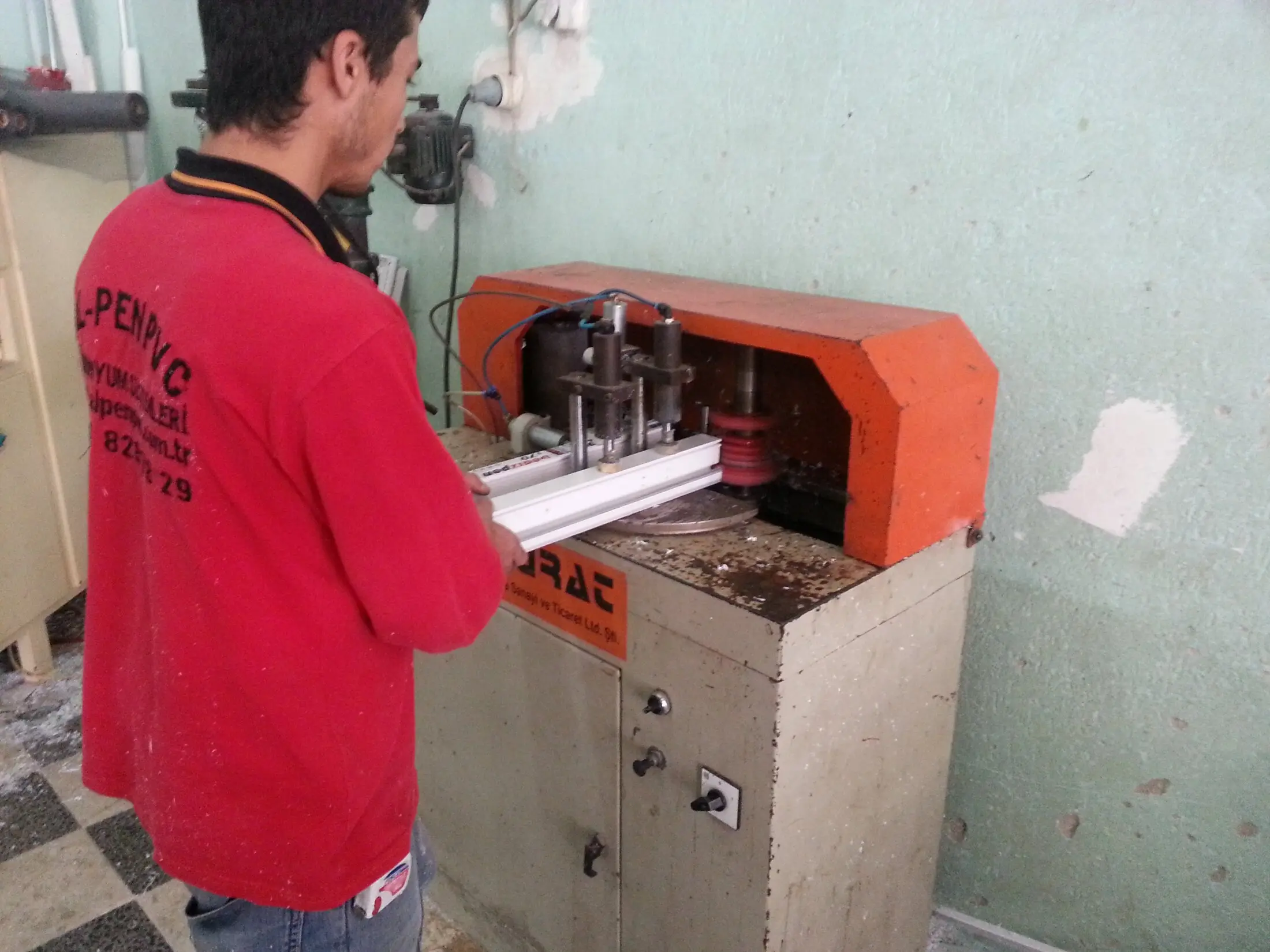 AL-PEN atölyesinde PVC profil kaynak makinesinde çalışan usta